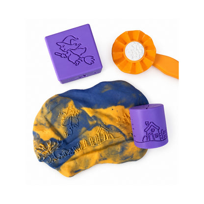 Halloween dough impressions beside purple stamps and an orange roller