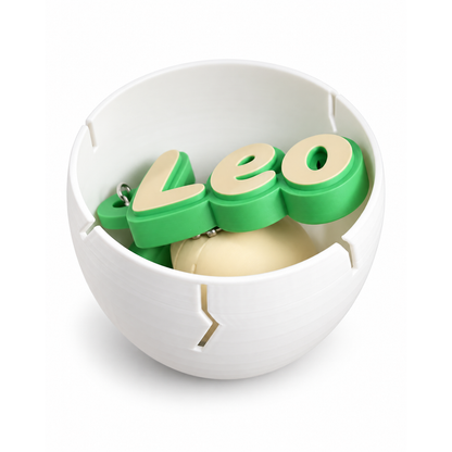 Example Leo name keychain and dinosaur clicker tucked inside the white egg included with the duo
