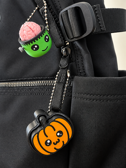Frankie and Pumpkin Pop clickers attached to a black bag; bag and other clicker not included