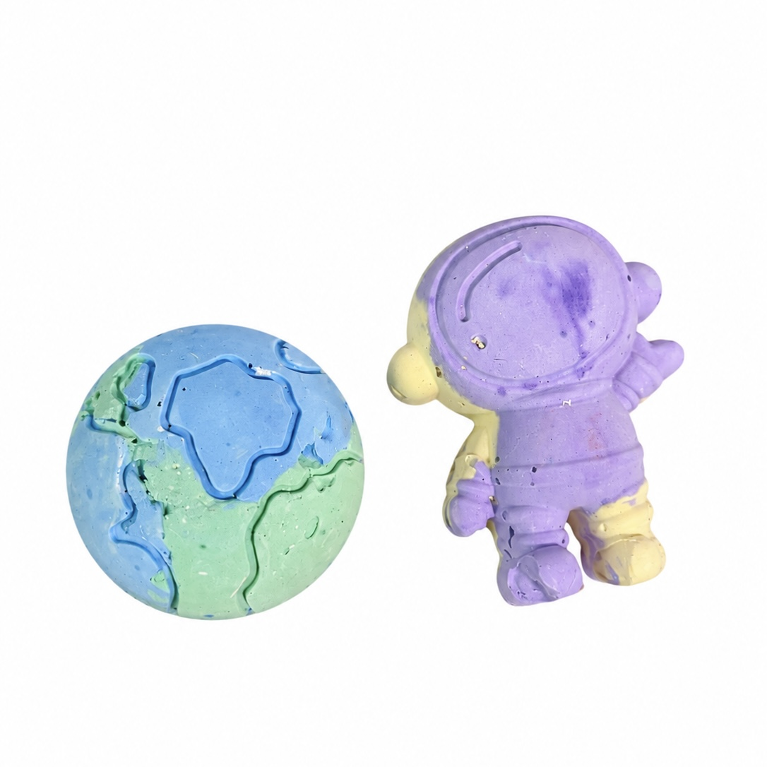 Purple and yellow astronaut chalk beside a blue and green Earth-shaped chalk