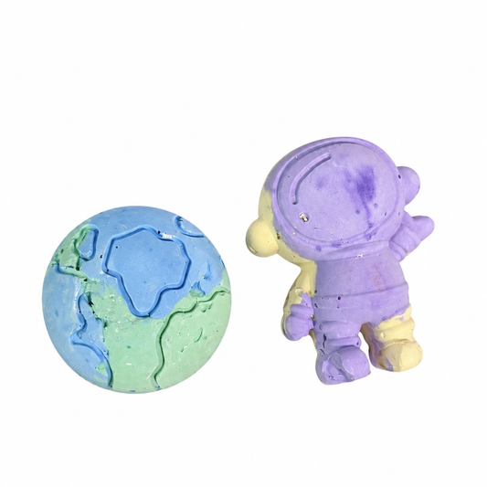 Purple and yellow astronaut chalk beside a blue and green Earth-shaped chalk