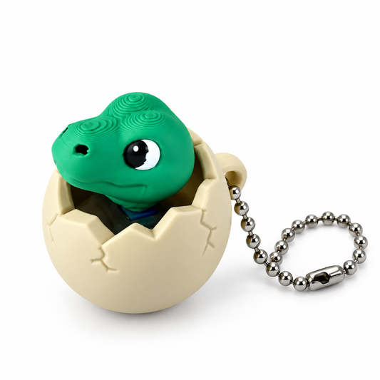 Green dinosaur clicker peeking out of a cream cracked egg with a silver ball chain