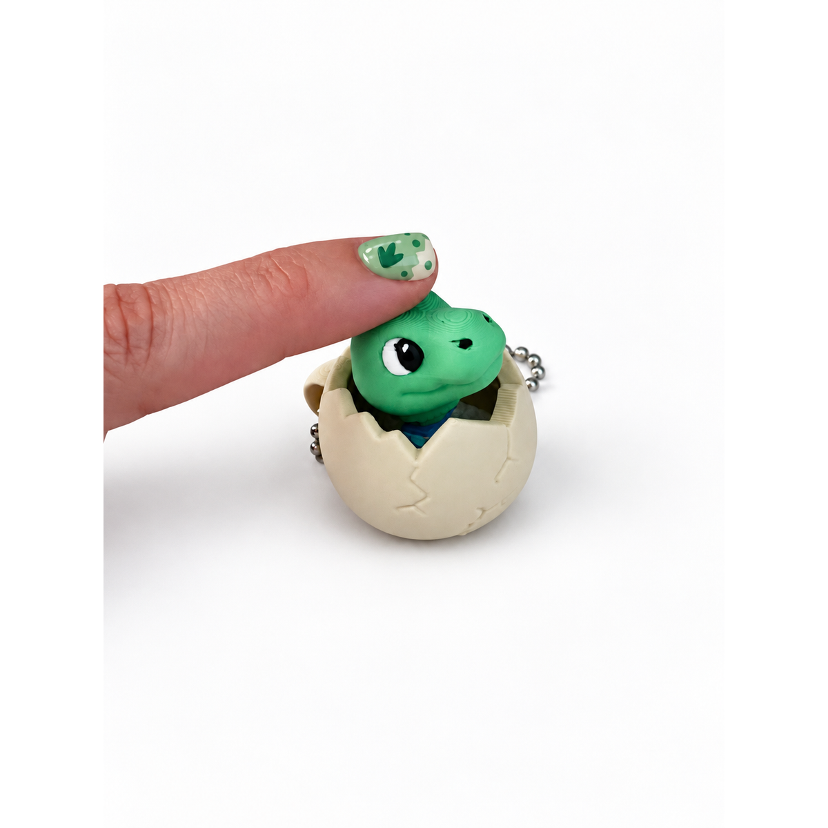 Finger pressing the dinosaur head of the Little Hatchling clicker