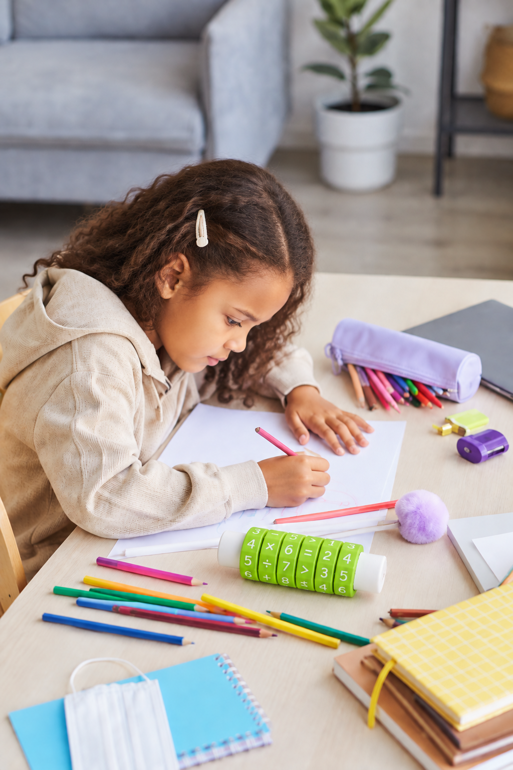 Child writing beside Spin and Solve with school supplies used as styling props
