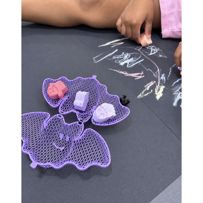 Halloween chalk drawing activity beside an open bat-shaped case