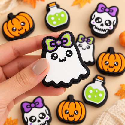 Hand holding Boo Bow Ghost in a styled display of several Halloween clickers