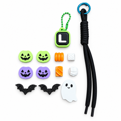 Unassembled Boo & You keychain components with black cord, example L initial clicker, Halloween pumpkins, bats, ghost and textured beads.