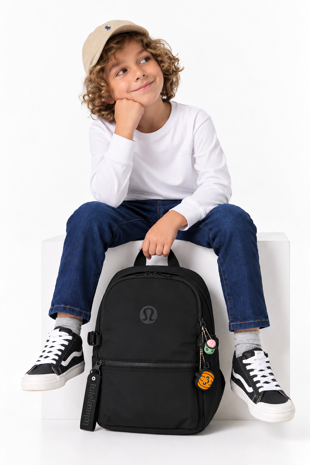 Child sitting with a backpack displaying Pumpkin Pop and another clicker; backpack and other clicker not included